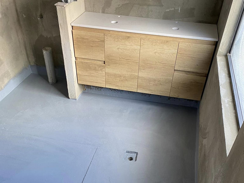 Bathroom mid-renovation: waterproofed floor with a timber-look vanity fitted