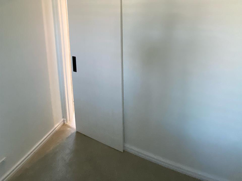 White sliding door partly open in a painted hallway